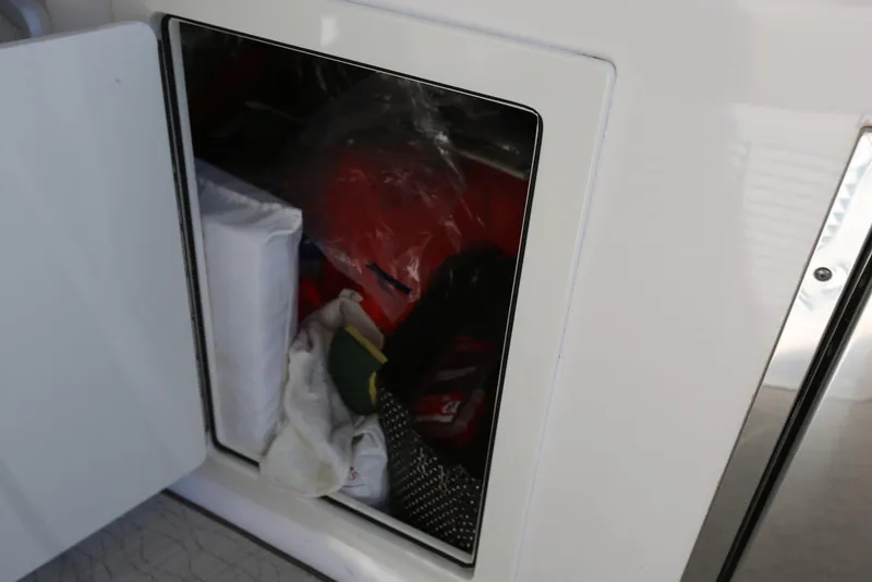 Slide: The Image of Storage compartment on a 2012 Regal 35 Sport Coupe boat, containing various items. - 25