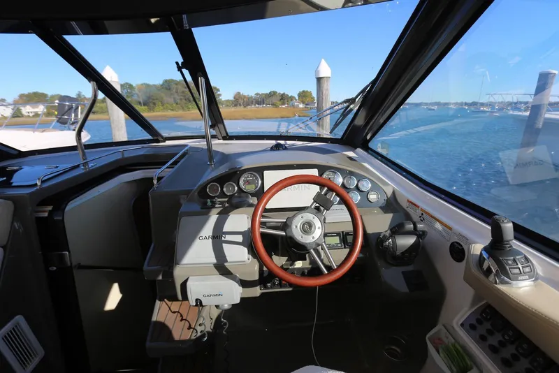 Slide: The Image of 2012 Regal 35 Sport Coupe helm with Garmin navigation, overlooking serene waters and marina. - 29