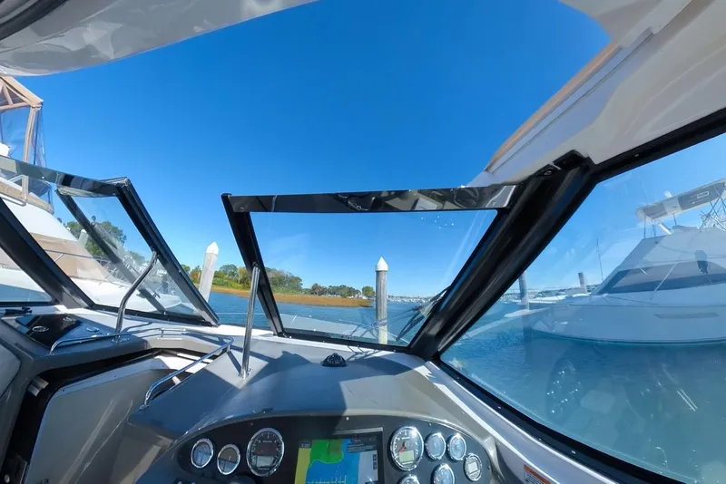 Slide: The Image of 2012 Regal 35 Sport Coupe cockpit view with clear blue sky and marina. - 40