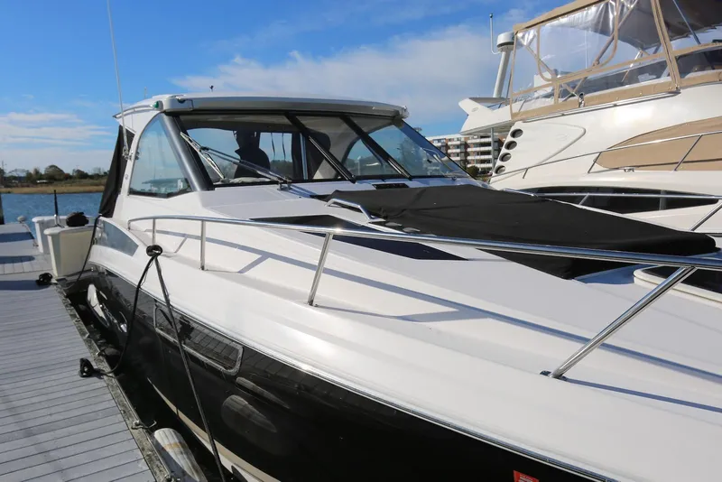 Slide: The Image of 2012 Regal 35 Sport Coupe docked at marina under clear blue sky. - 59