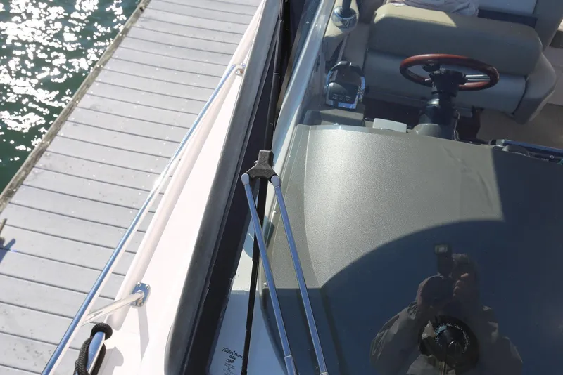 Slide: The Image of 2012 Regal 35 Sport Coupe boat docked, showing steering wheel and deck reflection. - 73