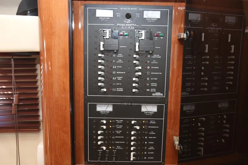Slide: The Image of Electrical control panel of 2012 Regal 35 Sport Coupe boat, featuring various switches and meters. - 92