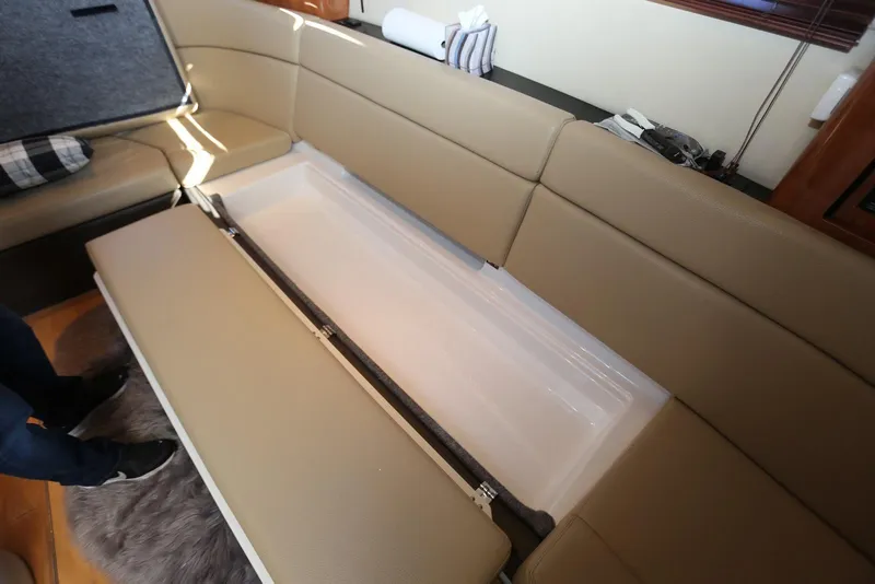 Slide: The Image of 2012 Regal 35 Sport Coupe interior with open storage compartment under beige seating. - 93