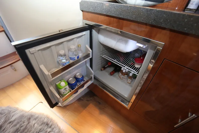 Slide: The Image of Mini fridge stocked with drinks inside a 2012 Regal 35 Sport Coupe yacht. - 94