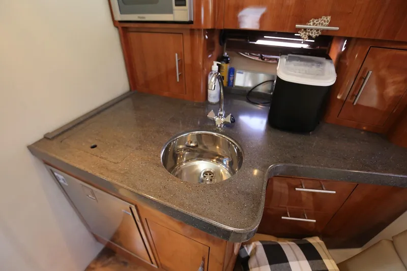 Slide: The Image of Compact kitchen area in a 2012 Regal 35 Sport Coupe with sink and countertop. - 95