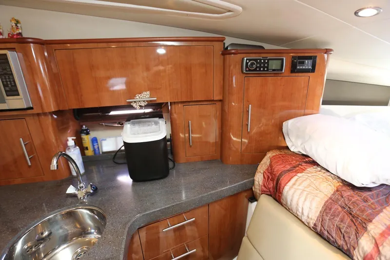 Slide: The Image of 2012 Regal 35 Sport Coupe interior with kitchenette and cozy sleeping area. - 97