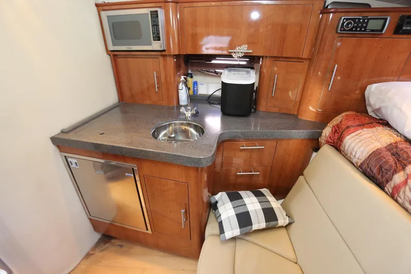 Slide: The Image of 2012 Regal 35 Sport Coupe interior with kitchenette, featuring sink, microwave, and seating area. - 98