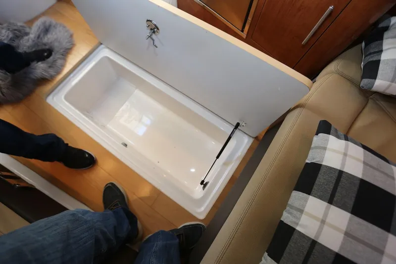 Slide: The Image of Interior storage compartment in 2012 Regal 35 Sport Coupe boat, with wooden flooring and seating. - 99