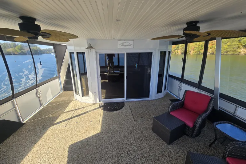 Slide: The Image of Spacious 2013 Thoroughbred houseboat interior with seating, ceiling fans, and scenic lake views. - 13