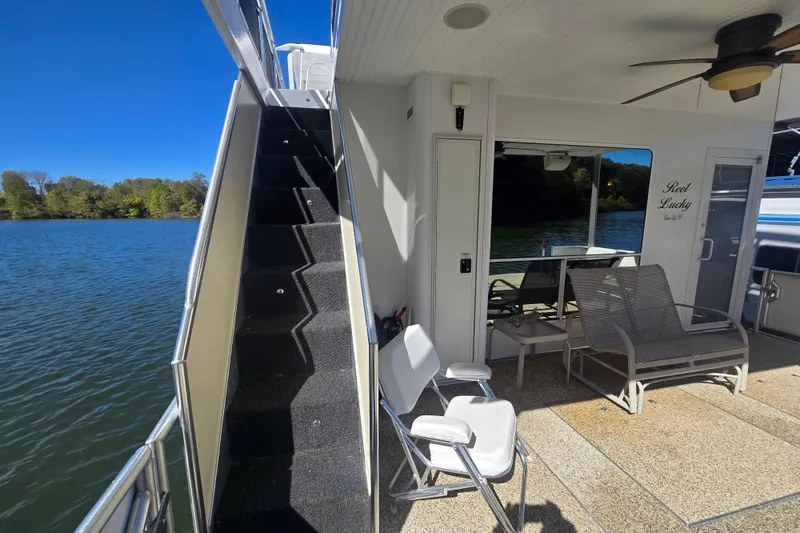 Slide: The Image of 2013 Thoroughbred houseboat with outdoor seating, stairs, and scenic lake view. - 20