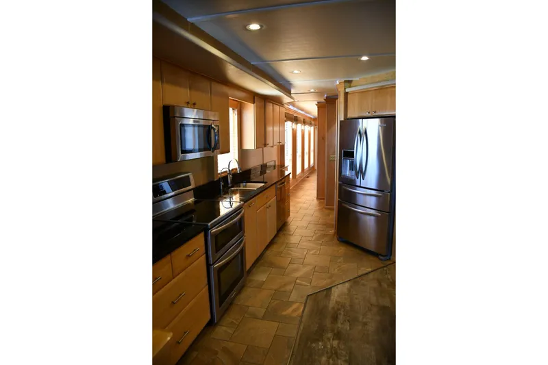 Slide: The Image of Modern kitchen in 2013 Thoroughbred model, featuring stainless steel appliances and wood cabinetry. - 29
