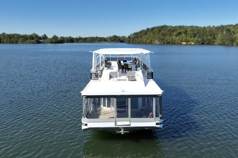 Slide: The Image of 2013 Thoroughbred 80'x 18' houseboat on a serene lake with lush green shoreline. - 4