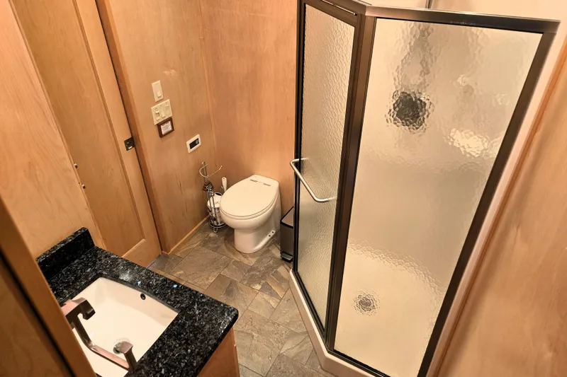 Slide: The Image of Modern bathroom in 2013 Thoroughbred model, featuring shower, toilet, and granite countertop sink. - 45