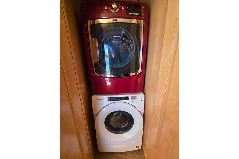 Slide: The Image of Stacked red and white washer and dryer in a compact wooden alcove. - 50