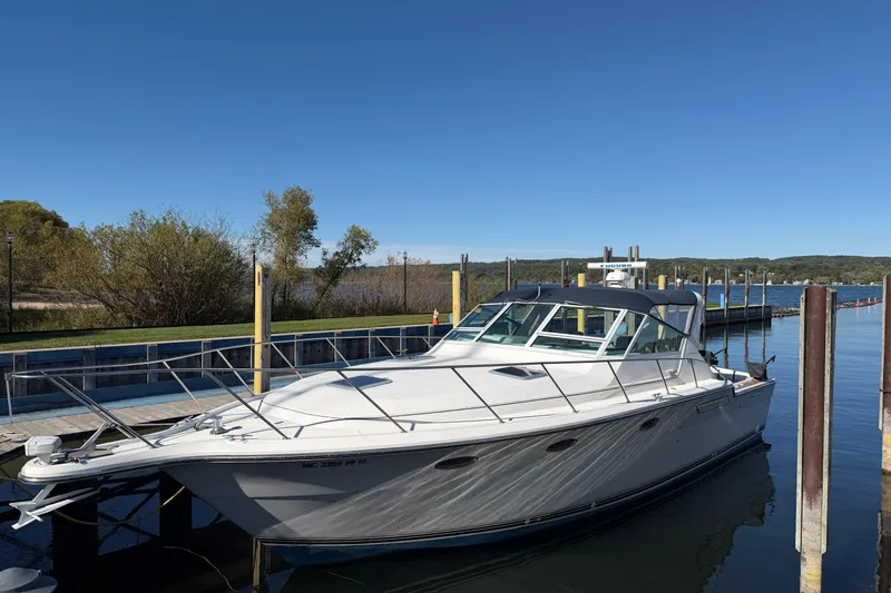 The Image of 1988 Tiara Yachts 3600 Open docked at a serene marina under clear blue skies. - 0