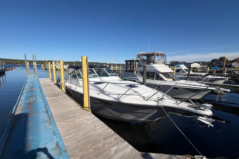 Slide: The Image of 1988 Tiara Yachts 3600 Open docked at marina under clear blue sky. - 11