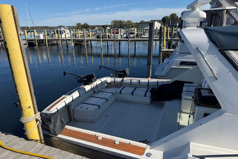 Slide: The Image of 1988 Tiara Yachts 3600 Open docked at a marina, featuring spacious seating area. - 18