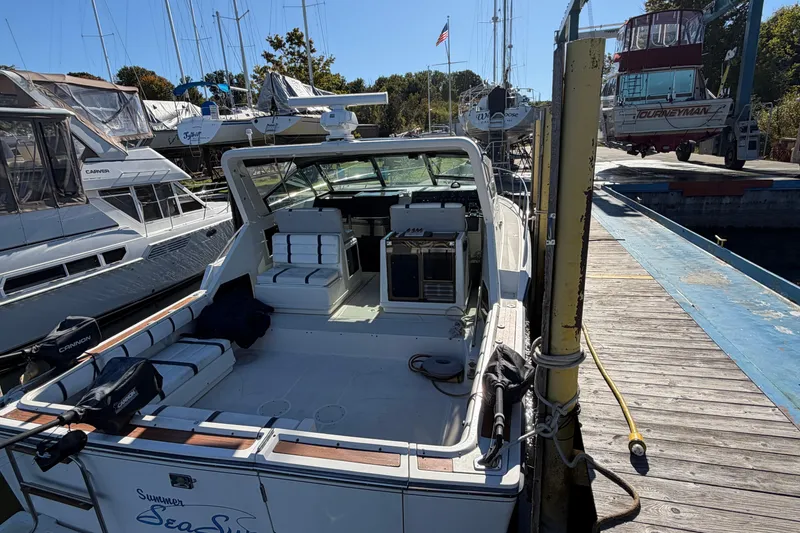 Slide: The Image of 1988 Tiara Yachts 3600 Open docked at marina, surrounded by other boats. - 20