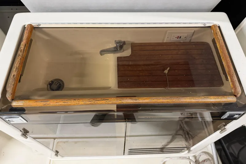 Slide: The Image of 1988 Tiara Yachts 3600 Open cabin interior with wooden accents and transparent cover. - 23