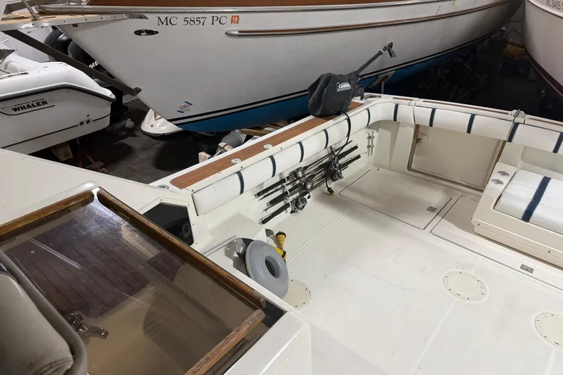 Slide: The Image of 1988 Tiara Yachts 3600 Open boat interior with fishing rods and seating. - 25