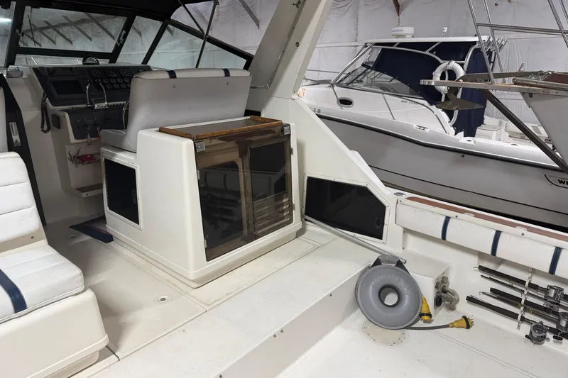 Slide: The Image of 1988 Tiara Yachts 3600 Open interior with helm, seating, and equipment in a marina setting. - 26