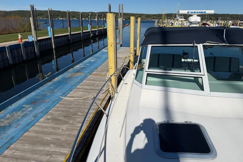 Slide: The Image of 1988 Tiara Yachts 3600 Open docked at a marina with scenic lake view. - 32