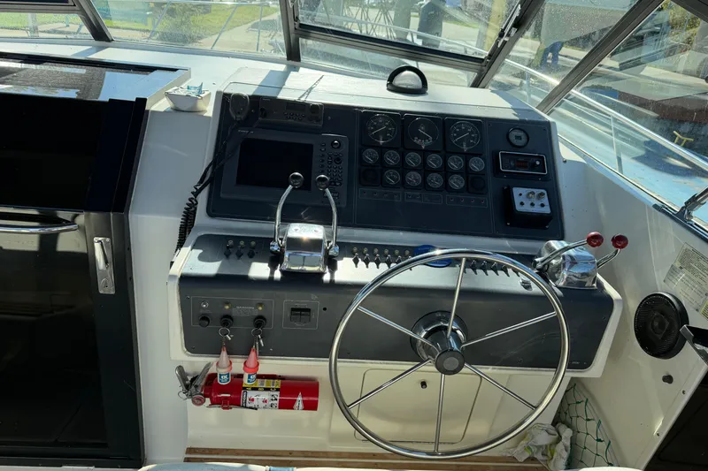 Slide: The Image of 1988 Tiara Yachts 3600 Open helm with steering wheel and control panel. - 36