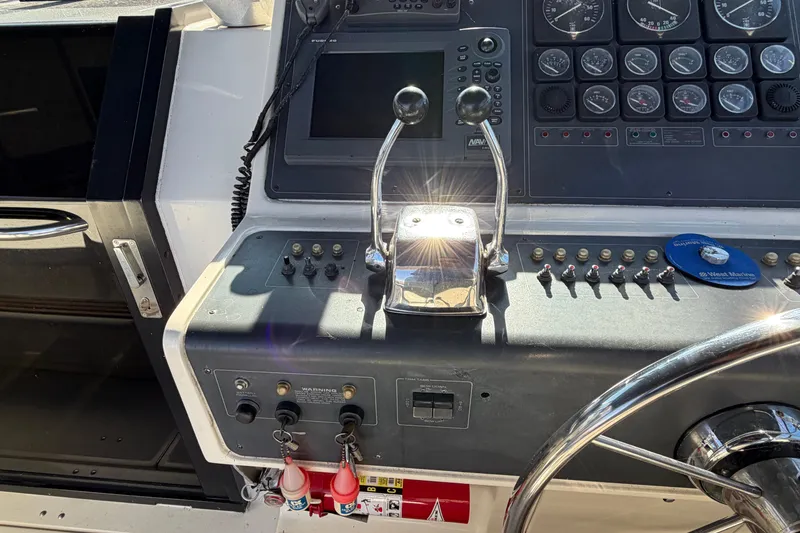 Slide: The Image of Control panel of a 1988 Tiara Yachts 3600 Open, featuring gauges and throttle levers. - 40