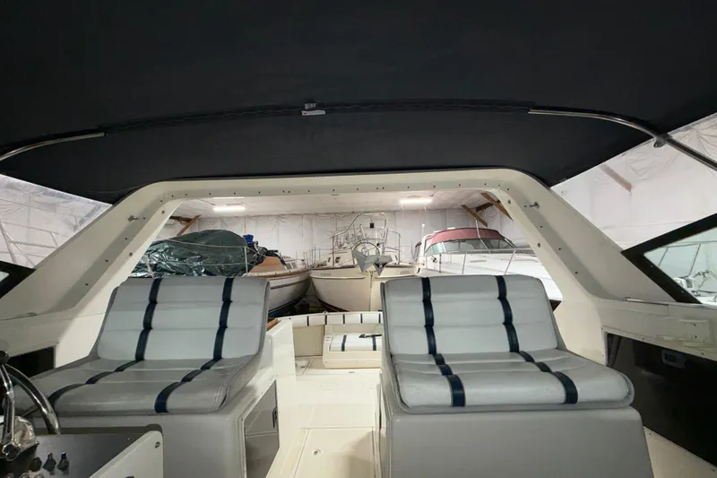 Slide: The Image of 1988 Tiara Yachts 3600 Open interior with striped seating, stored indoors. - 42