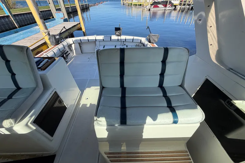 Slide: The Image of 1988 Tiara Yachts 3600 Open interior with cushioned seating and dockside view. - 43