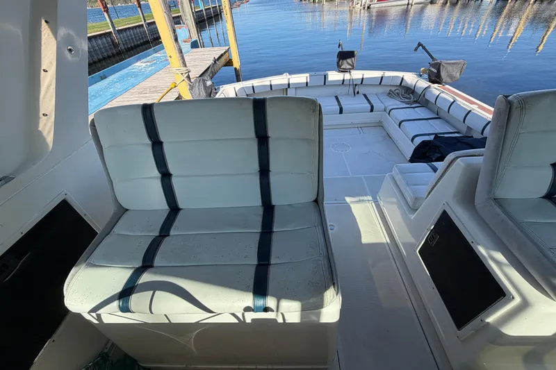 Slide: The Image of 1988 Tiara Yachts 3600 Open interior with white seating and dock view. - 44