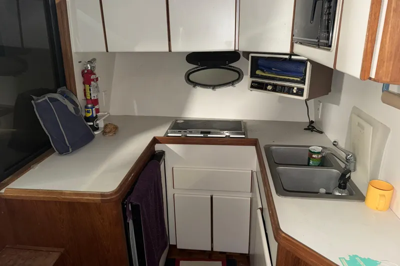 Slide: The Image of 1988 Tiara Yachts 3600 Open kitchen with sink, stove, and storage cabinets. - 49
