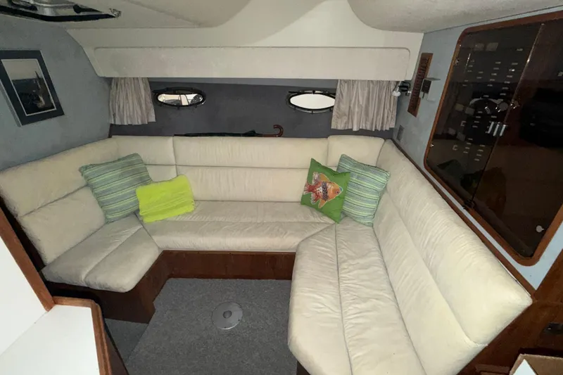 Slide: The Image of 1988 Tiara Yachts 3600 Open interior with cream seating and decorative pillows. - 52