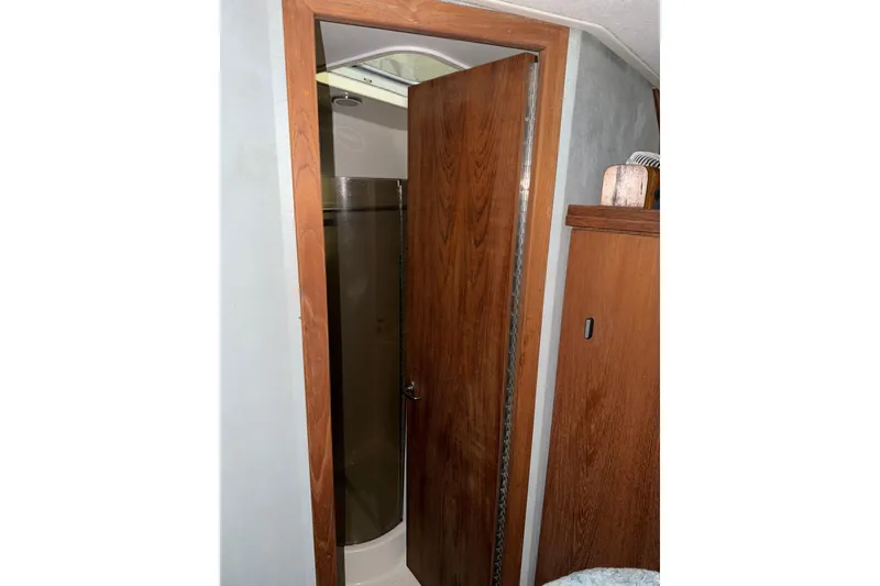 Slide: The Image of 1988 Tiara Yachts 3600 Open bathroom with wooden door and compact shower. - 58