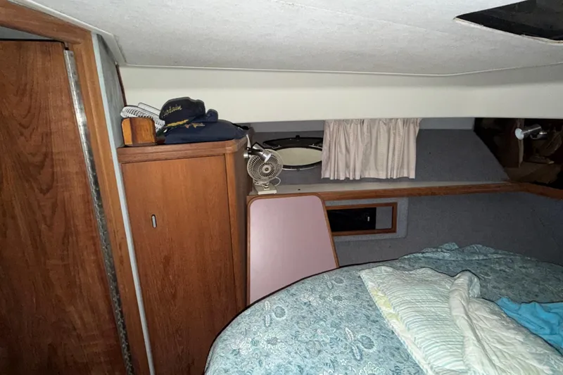 Slide: The Image of 1988 Tiara Yachts 3600 Open cabin interior with bed, wooden cabinet, and small fan. - 60