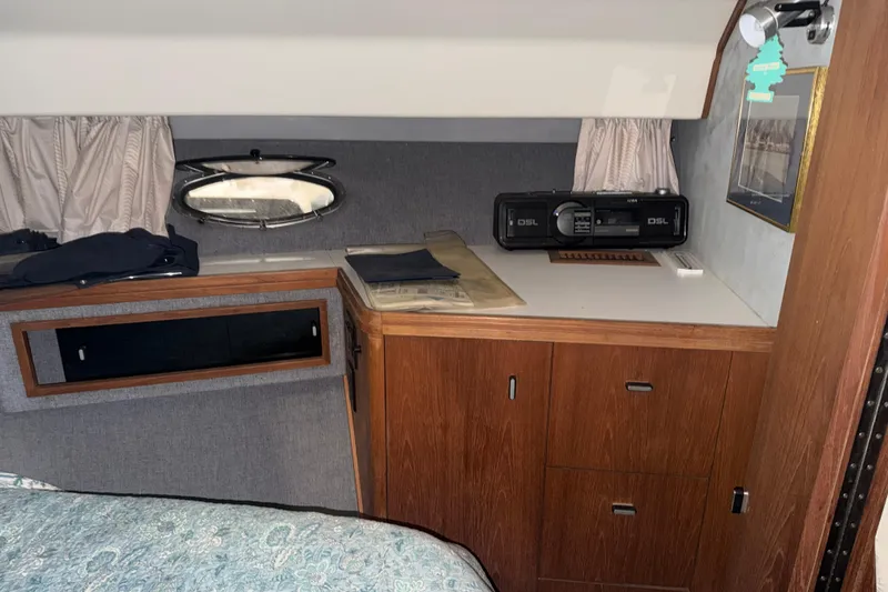 Slide: The Image of 1988 Tiara Yachts 3600 Open cabin interior with wood cabinetry and porthole window. - 62