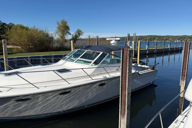 Slide: The Image of 1988 Tiara Yachts 3600 Open docked in a serene marina setting. - 7