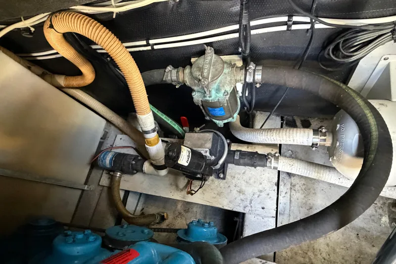 Slide: The Image of Engine compartment of 1988 Tiara Yachts 3600 Open, showcasing hoses and mechanical components. - 70