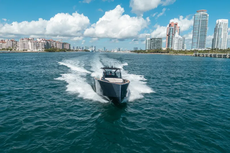 Slide: The Image of 2023 Pardo Yachts 43 cruising in sunny coastal waters with city skyline backdrop. - 34