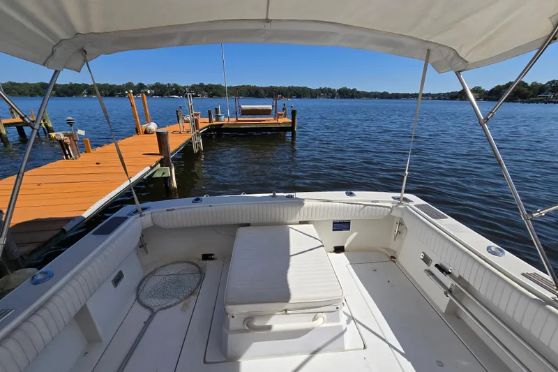 Slide: The Image of 1984 Bayliner 2802 Trophy boat docked on a sunny lake with clear skies. - 18