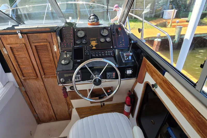 Slide: The Image of 1984 Bayliner 2802 Trophy boat cockpit with steering wheel and control panel. - 32