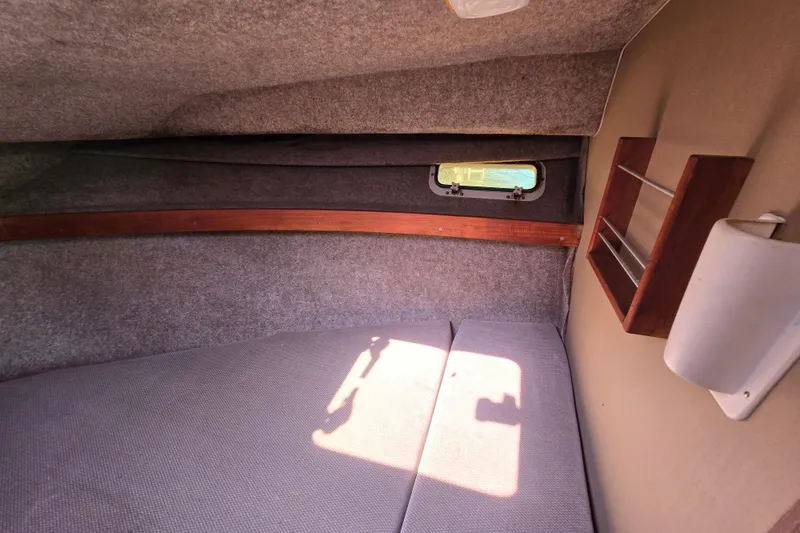 Slide: The Image of 1984 Bayliner 2802 Trophy cabin interior with window, shelf, and cushioned seating. - 38