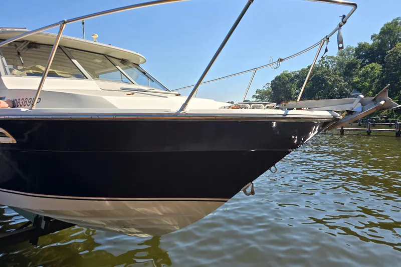 Slide: The Image of 1984 Bayliner 2802 Trophy boat docked on a sunny day, side view. - 5