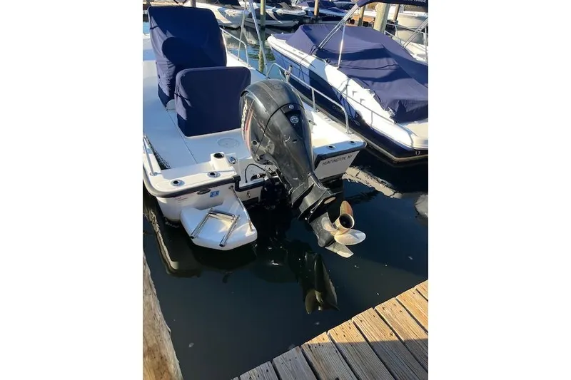 Slide: The Image of 2017 Boston Whaler 190 Montauk boat docked with covered seats and outboard motor. - 2