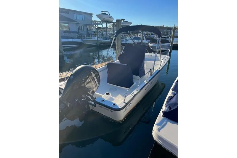 Slide: The Image of 2017 Boston Whaler 190 Montauk boat docked at a marina under clear skies. - 3