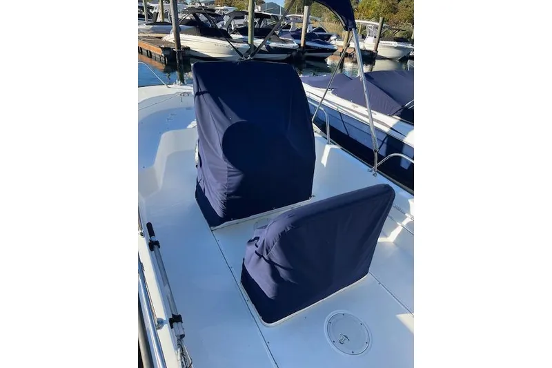 Slide: The Image of 2017 Boston Whaler 190 Montauk boat with blue seat covers at a marina. - 6