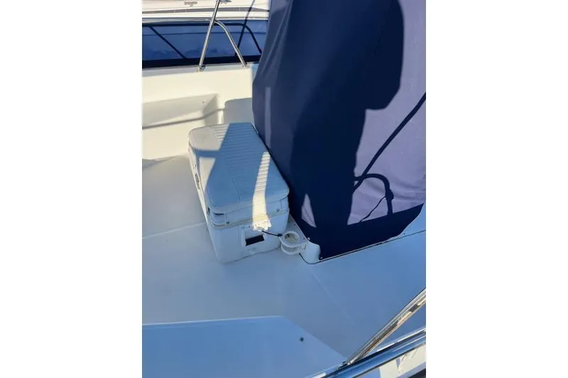 Slide: The Image of 2017 Boston Whaler 190 Montauk boat interior with cooler and blue cover. - 8