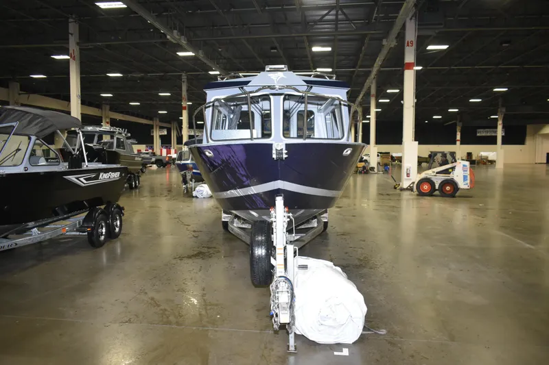 Slide: The Image of 2026 KingFisher 2825 Coastal Express boat displayed indoors on a trailer. - 11