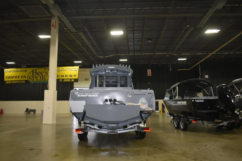 Slide: The Image of 2026 KingFisher 2825 Coastal Express boat displayed indoors at a showroom. - 12