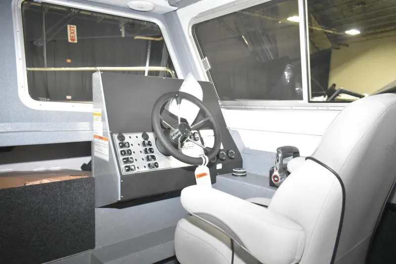Slide: The Image of Interior of 2026 KingFisher 2825 Coastal Express boat, featuring steering wheel and control panel. - 21